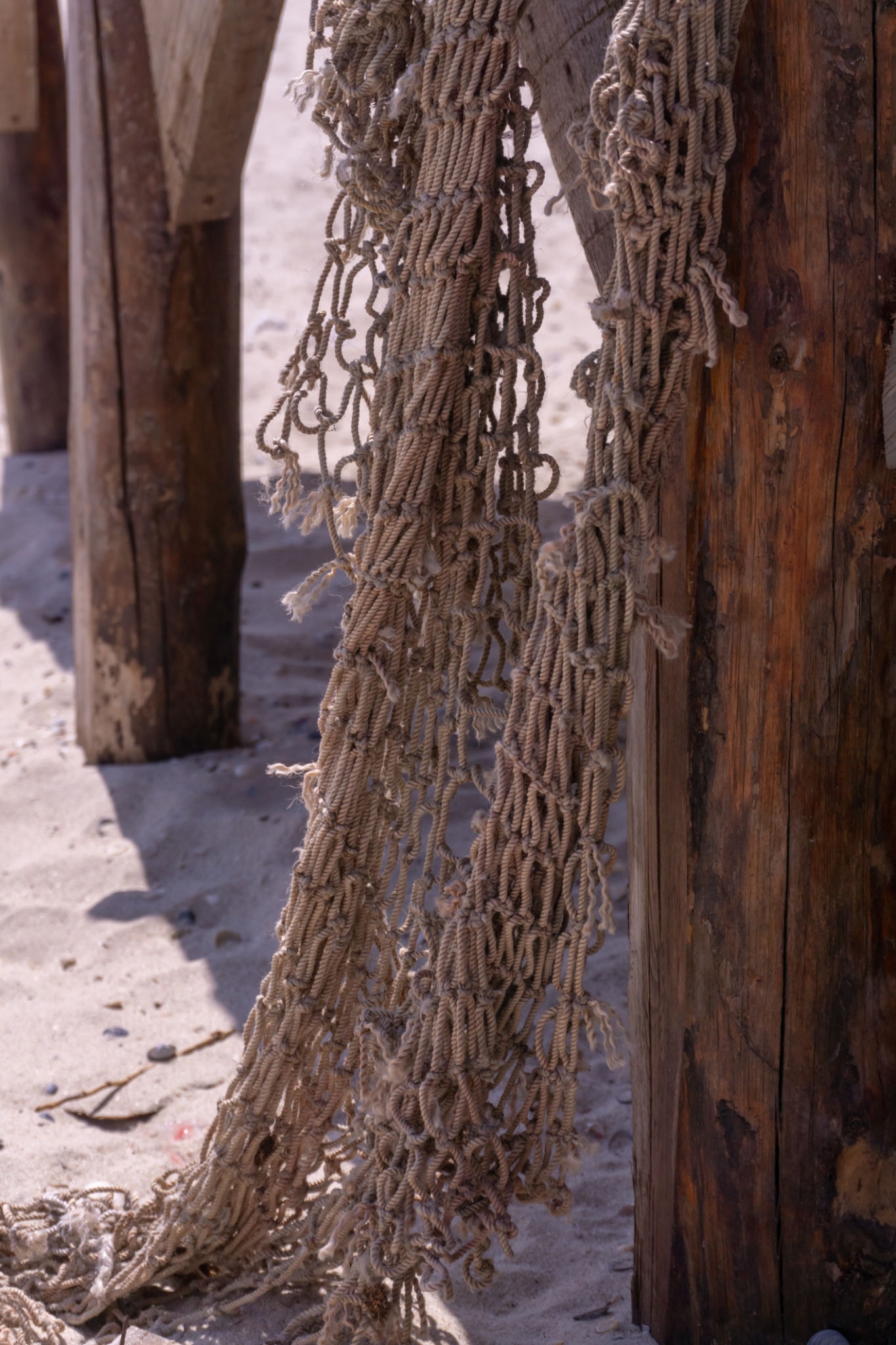 Weathered fishing nets hanging from a pier — a nod to the coastal heritage of 153 Real Estate